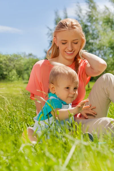 Mother and her child together in the green field — Stock Photo, Image