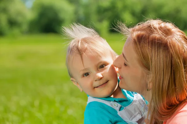 Matka, líbat její dítě v tváři v létě — Stock fotografie