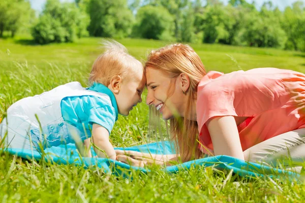 Gelukkig moeder en kind met voorhoofd dicht bij elkaar — Stockfoto