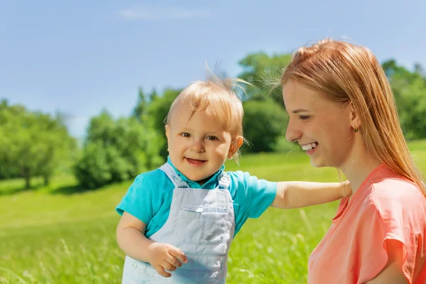 Mother and her kid together in the green field — Stock Photo, Image