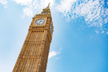 İkonik Big Ben saat kulesi parlak mavi gökyüzüne karşı dimdik duruyor. Karmaşık mimari detaylarını gözler önüne seriyor. Londra 'da turistler için tarihi bir dönüm noktası.