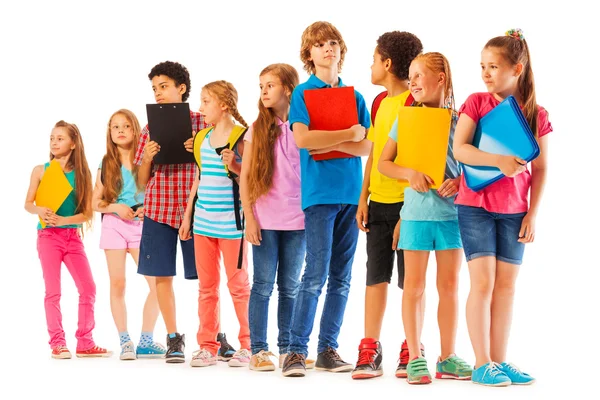 Schoolkinderen permanent in de lijn met boeken — Stockfoto