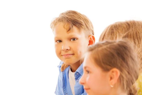 Bel ritratto di ragazzo tra i bambini con un sorriso modesto — Foto Stock