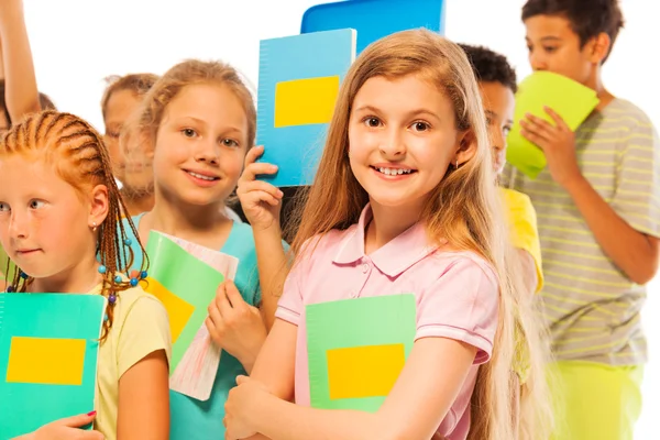 Girl with textbook in large group of children — Stock Photo, Image