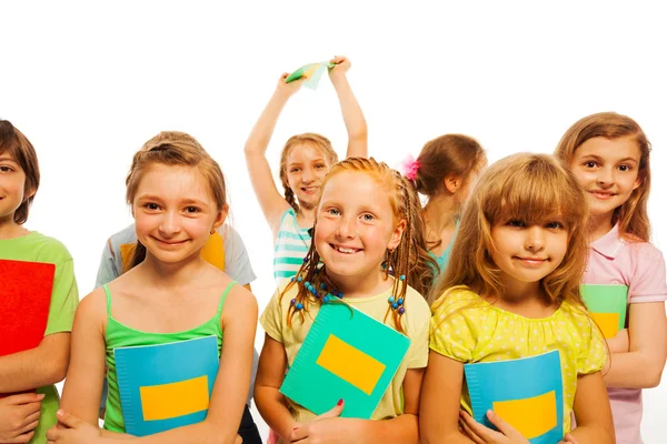 Chicas y niños sonrientes sosteniendo libros de texto — Foto de Stock