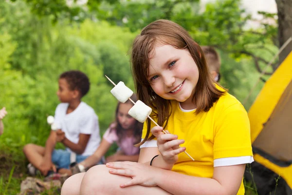 Krásná dívka drží marshmallows u stanu — Stock fotografie