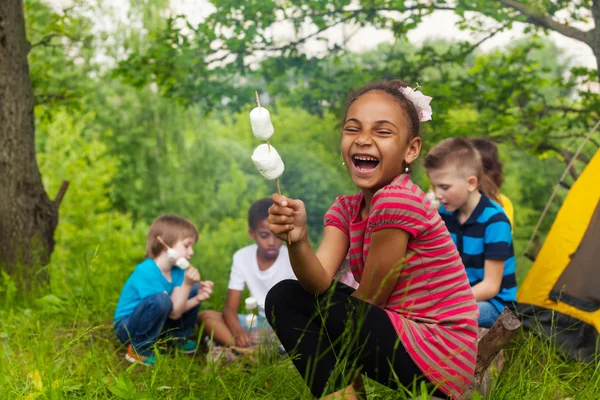 Laughing African girl holds stick with smores — Stock Photo, Image