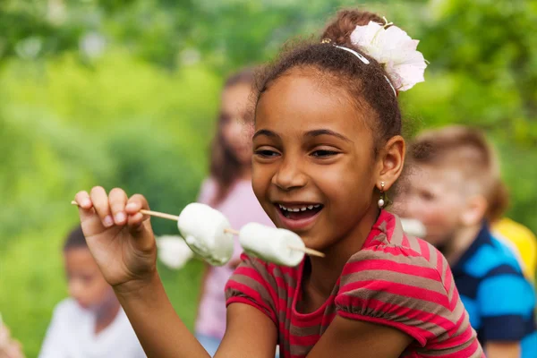 Menina africana feliz segurando pau com marshmallow — Fotografia de Stock