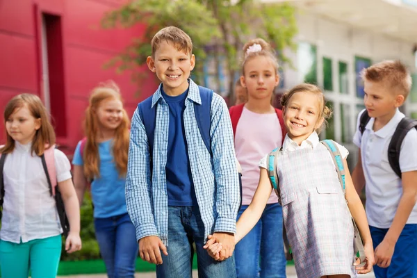 Grupp av barn med ryggsäckar nära skolbyggnaden — Stockfoto