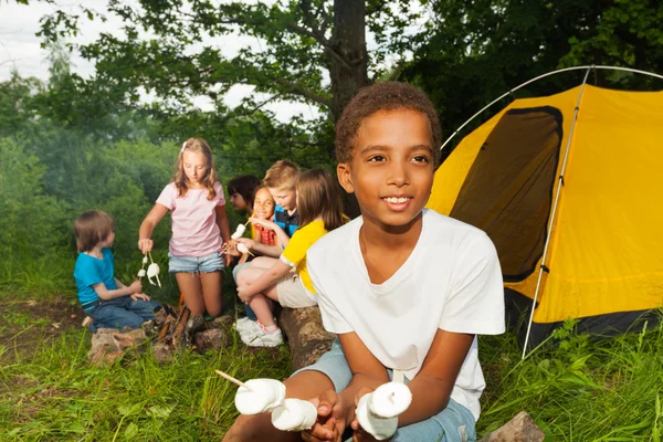 Menino africano acampando e segurando marshmallow — Fotografia de Stock