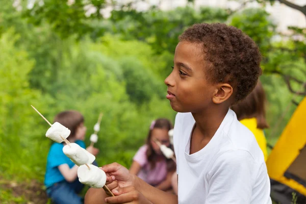 Africké chlapec drží hůl s marshmallows — Stock fotografie
