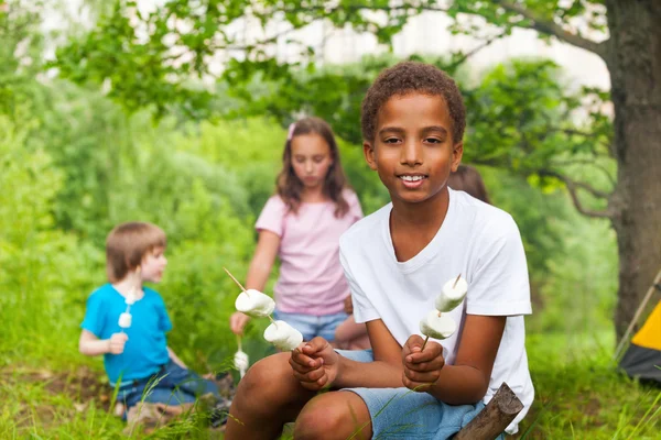 Carino ragazzo africano con marshmallows durante il campeggio — Foto Stock