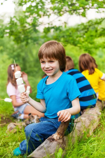 Positivo pequeno menino segurando vara com marshmallows — Fotografia de Stock