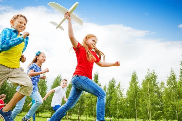 Vista de baixo de menina segurando grande avião brinquedo — Fotografia de Stock