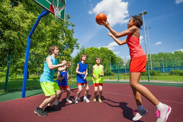 Подростки играют в баскетбол на земле — стоковое фото