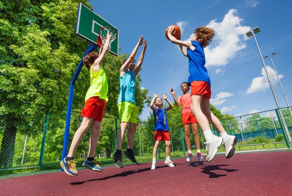 Підлітки стрибають за м'ячем під час гри в баскетбол — стокове фото