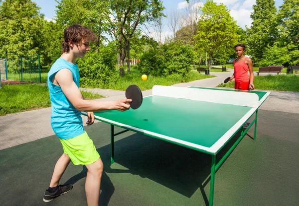 Afrykańska dziewczyna i chłopak gra ping-pong poza — Zdjęcie stockowe