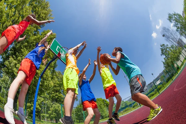 Fisheye view from below of teens during basketball — Stock Photo, Image