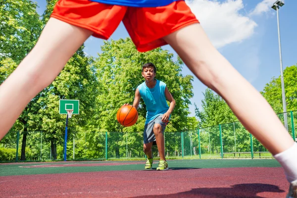 Boy with ball view between two legs of player — Stock Image Boy with ball view between two legs of player Royalty Free Stock Photos