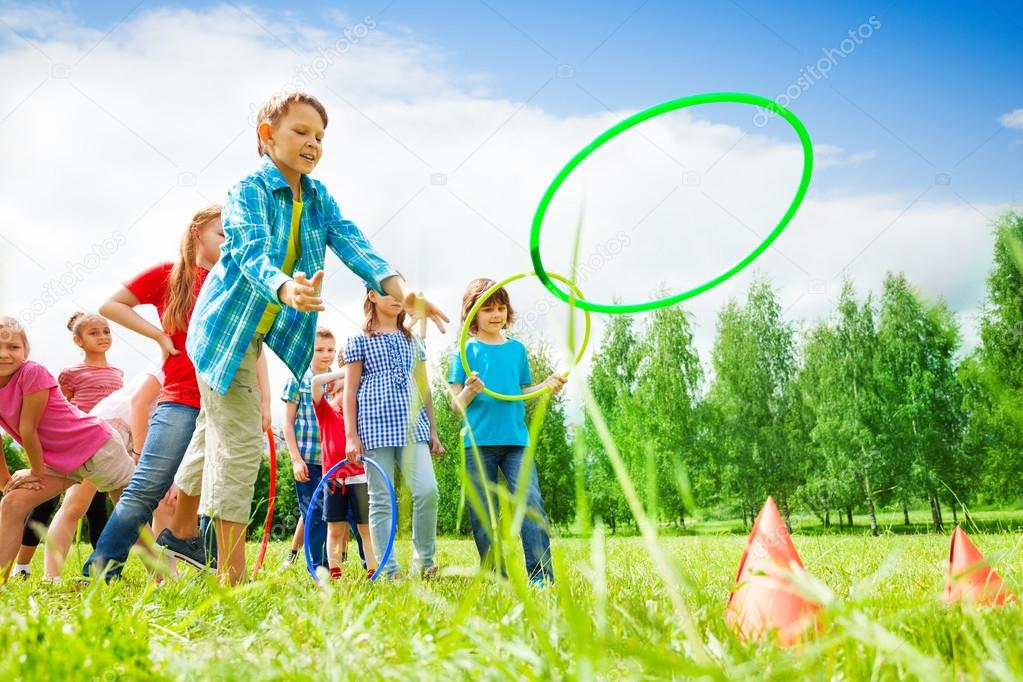 Children playing and throwing colorful hoops