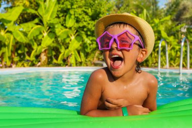 Boy in sunglasses in swimming  pool clipart