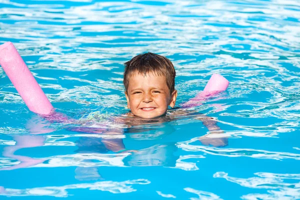 Jongen leert om te zwemmen met zwembad noodle — Stockfoto