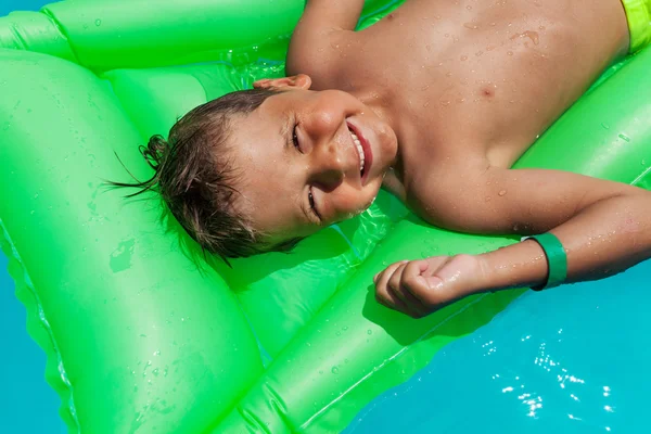 Chlapec relaxační na zelené matrace — Stock fotografie