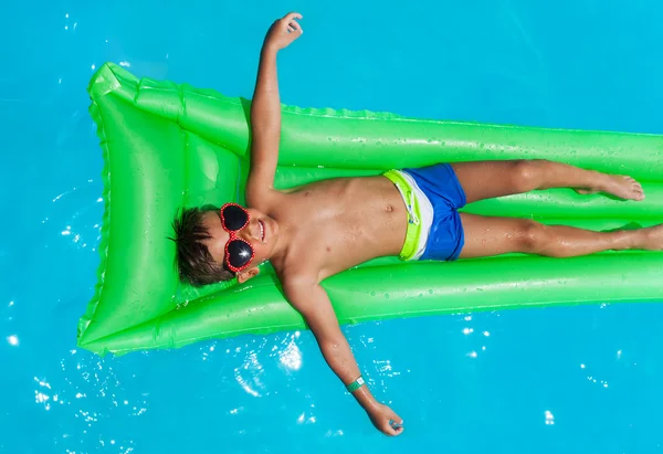 Niño usando gafas de sol relajante en el colchón —  Fotos de Stock