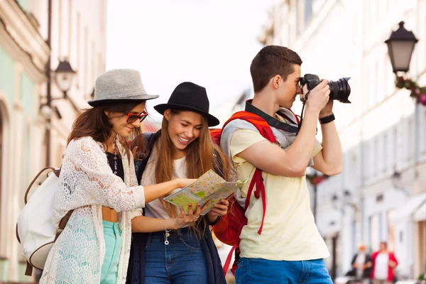 Amigos junto con el mapa de la ciudad y la cámara — Foto de Stock