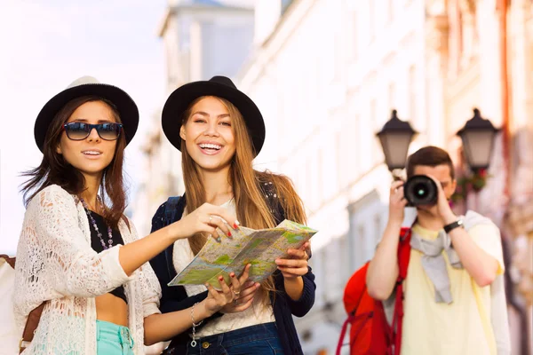 Mädchen halten Stadtplan in der Hand und Burschen schießen — Stockfoto