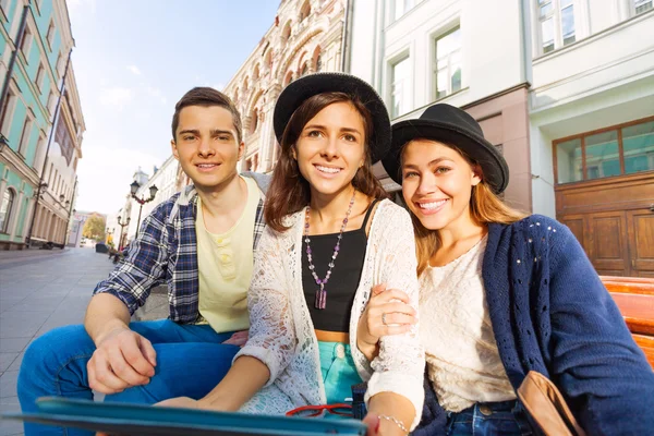 Friends sit on the bench together — Stockfoto