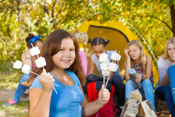 Flickan har pinnar med marshmallow — Stockfoto
