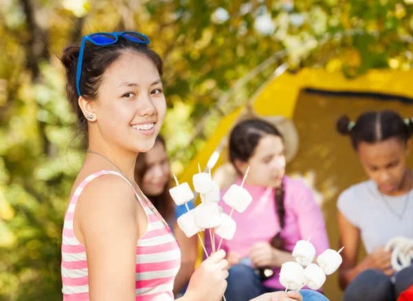 Ragazza tiene bastoni con marshmallow — Foto Stock