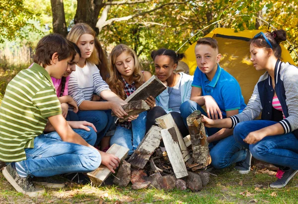 Teens setting up bonfire together — Stock Photo, Image