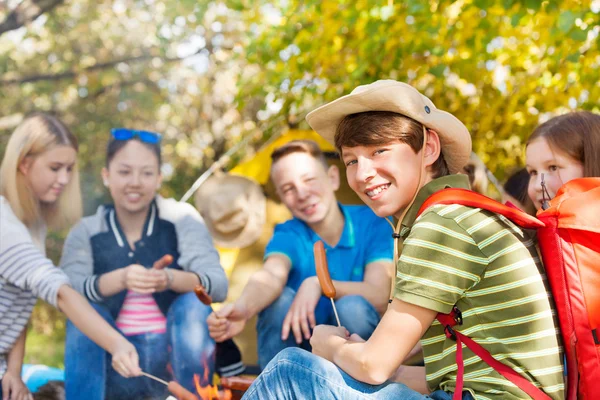 Amigos con salchichas palitos en el bosque — Foto de Stock