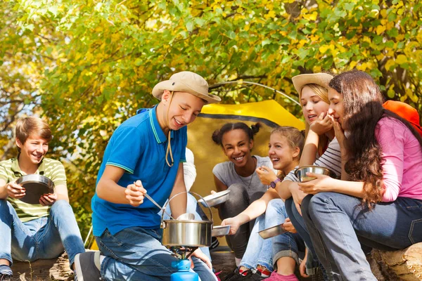 Boy cooks soup in pot — Stock Photo, Image