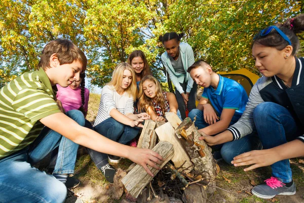 Friends construct bonfire together — Stock Photo, Image