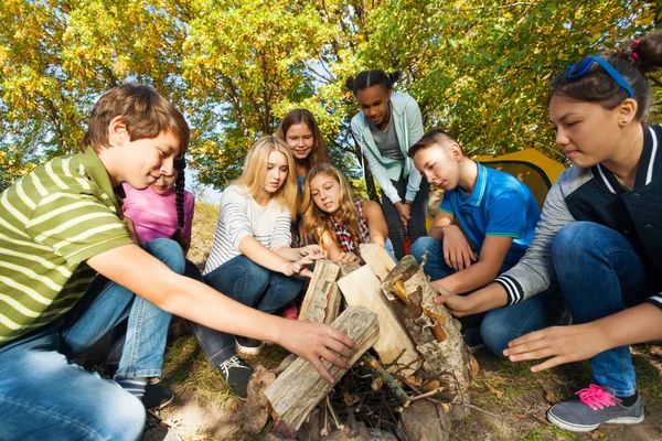 Freunde bauen gemeinsam Lagerfeuer — Stockfoto