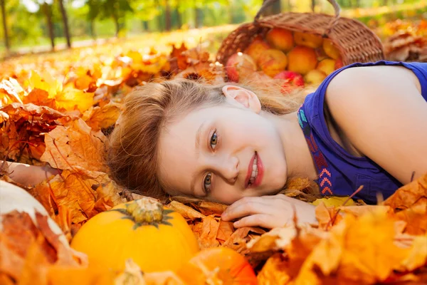 Chica en hojas con calabaza y manzanas — Foto de Stock