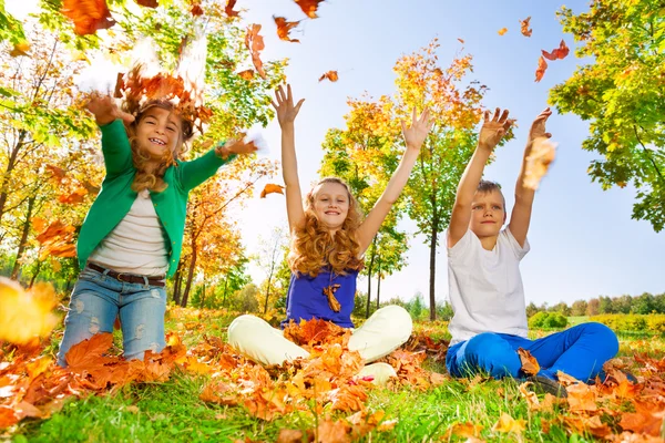 Los niños lanzan y juegan con hojas — Foto de Stock