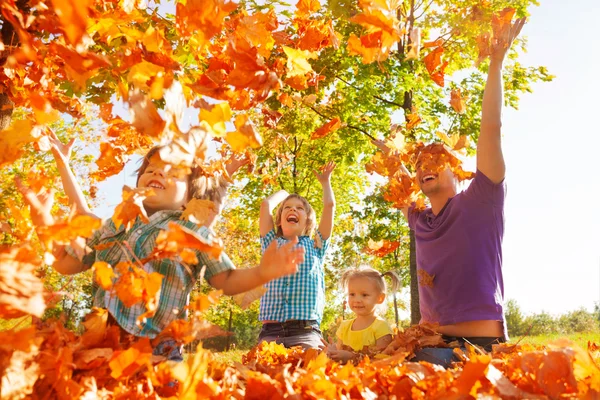 Familia feliz lanzando hojas — Foto de Stock