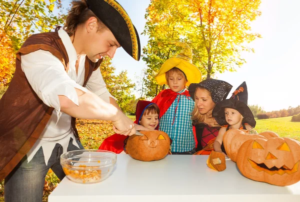 Father in pirate costume crafts Jack-O'-Lantern — Stock Photo, Image