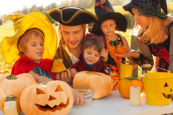 Family in pirate and witch costumes crafting — Stockfoto