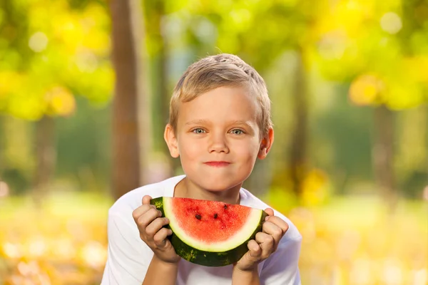 Junge mit Wassermelone sitzt im Wald — Stockfoto