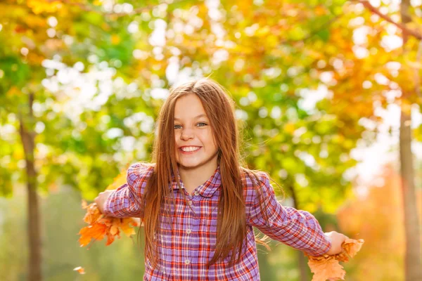 Menina feliz jogar folhas de bordo — Fotografia de Stock