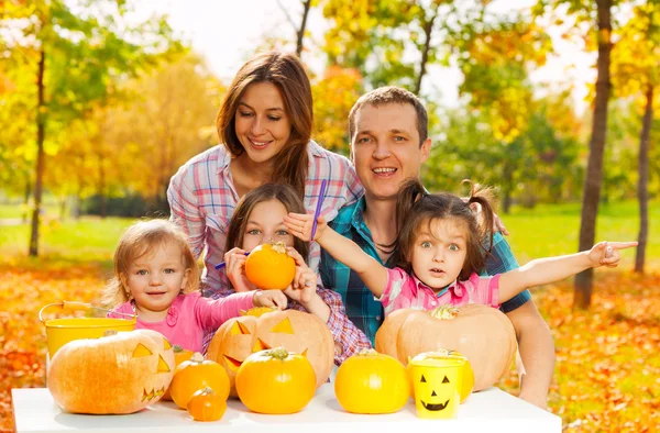 Family carve pumpkins for Halloween in the garden — Stock Photo, Image