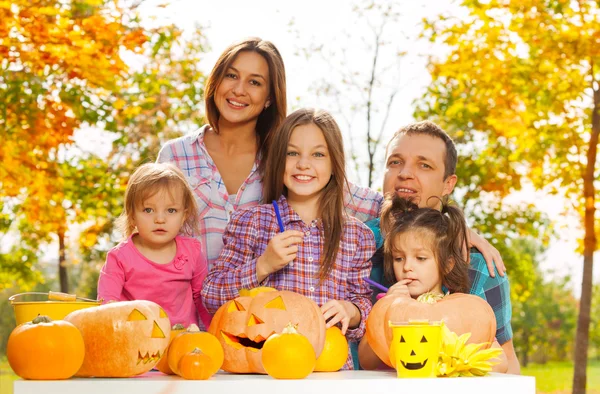 Familia tallar calabazas de miedo en el jardín — Foto de Stock