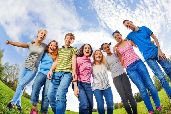 Friends stand on grass in row Stock Image