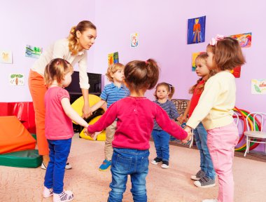 Teacher and group of kids in kindergarten clipart