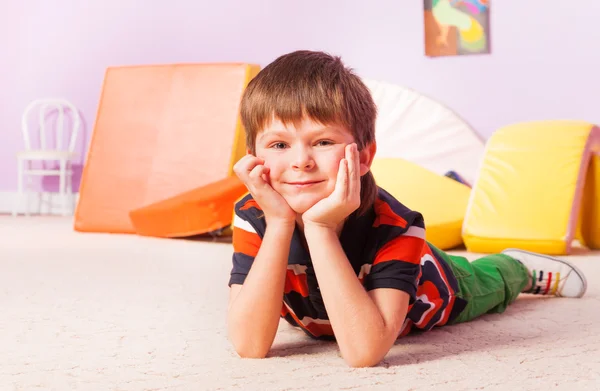 Boy lay on floor and hold head with hands — Stock Photo, Image